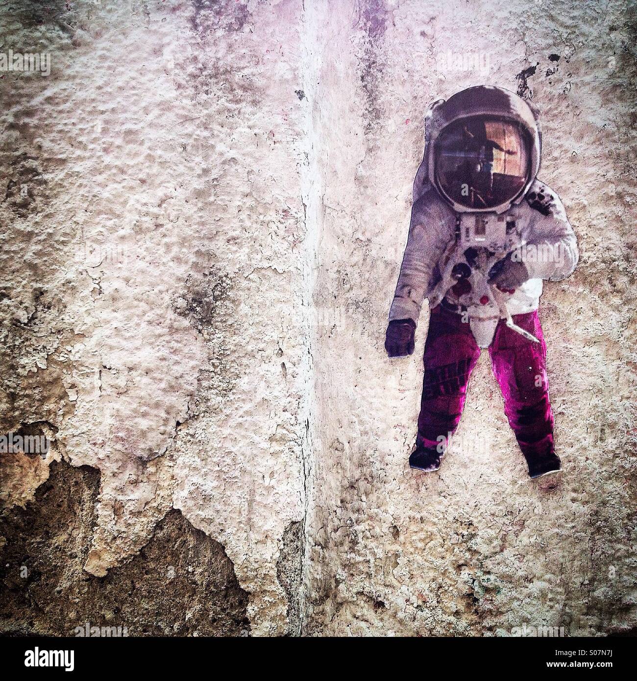 A sticker of an astronaut wearing purple clothes decorate a wall in Colonia Roma, Mexico City,Mexico - Smartphone Captured Stock Image