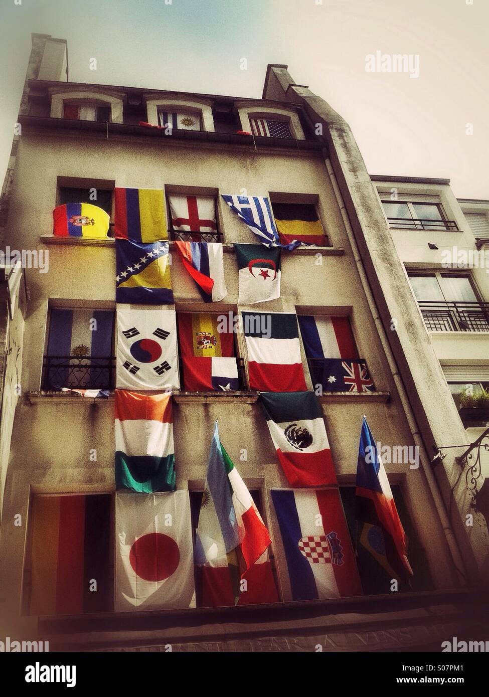 Flags of different countries of the world on facade of building in Paris - Smartphone Captured Stock Image