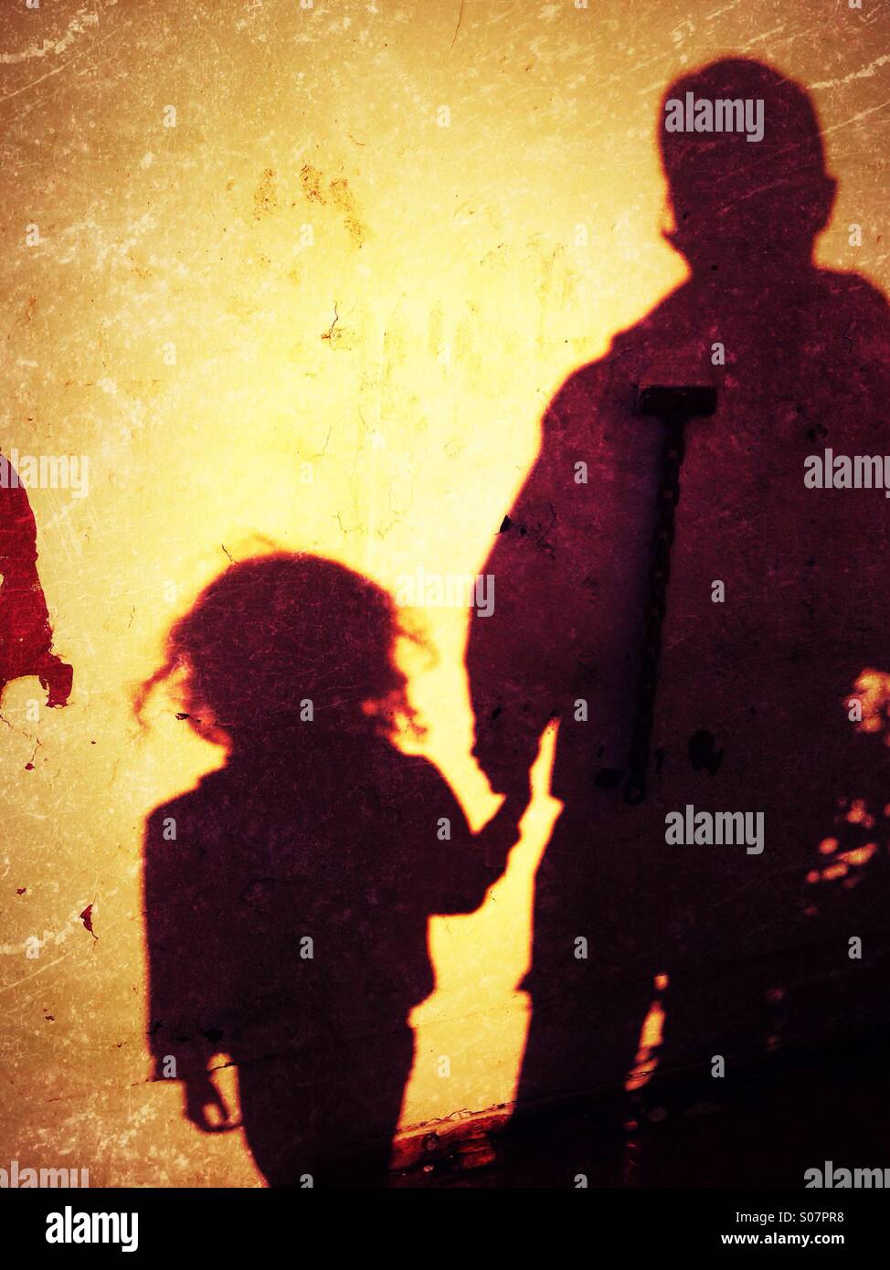 Shadow of man and young girl on wall Stock Photo