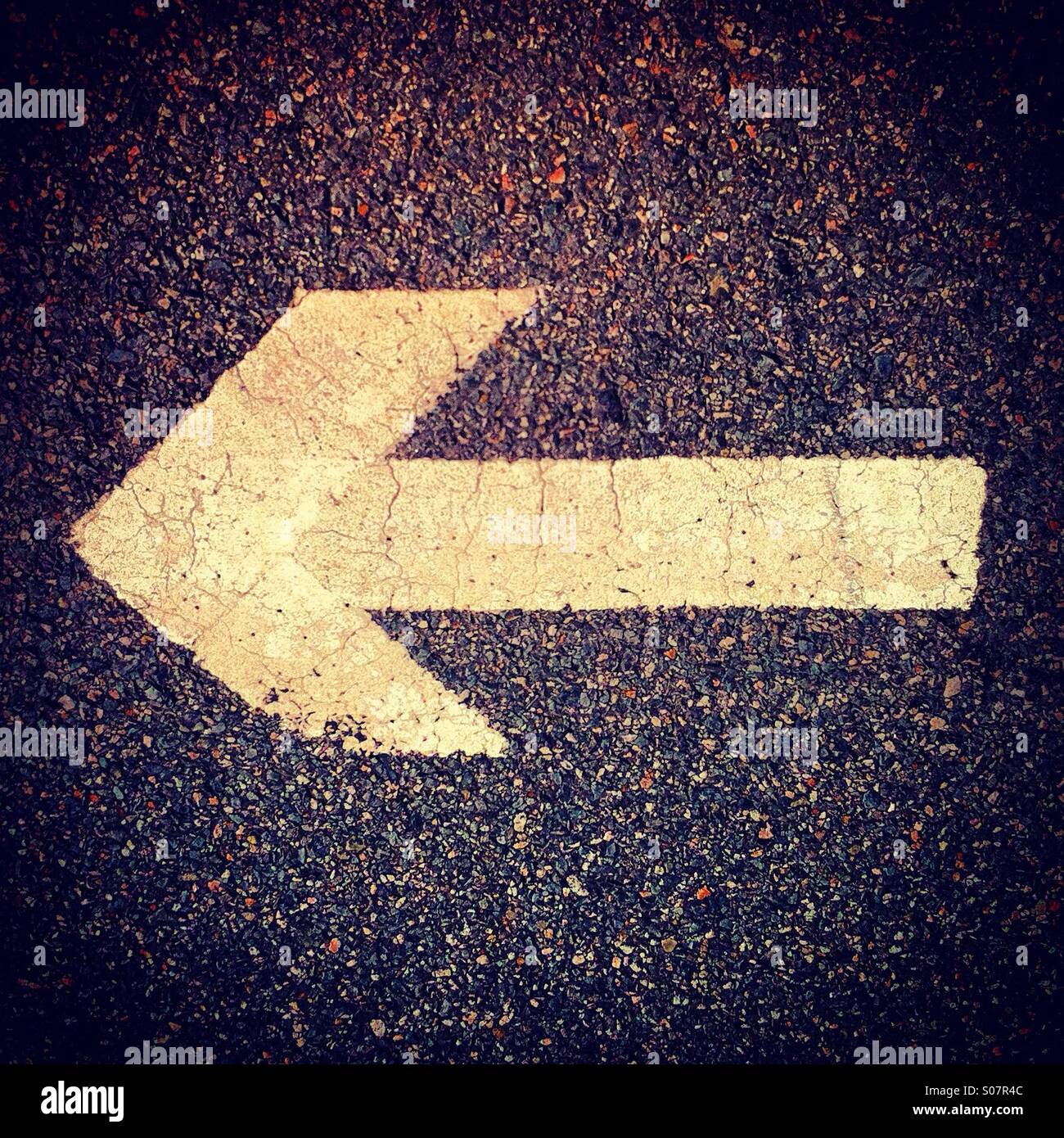 White arrow on the road showing left - Smartphone Captured Stock Image