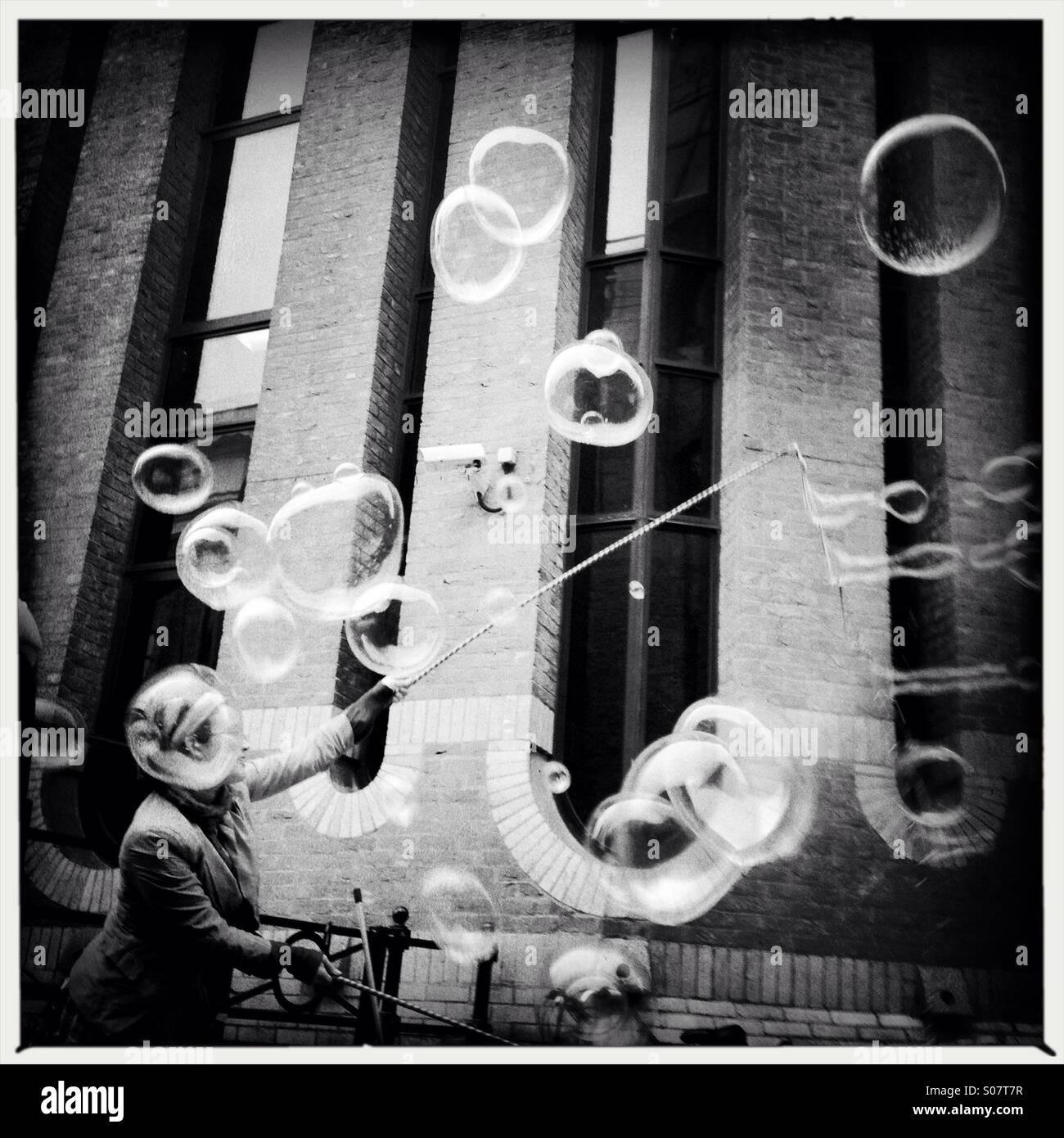 Street artist making huge bubbles in London southbank - Smartphone Captured Stock Image