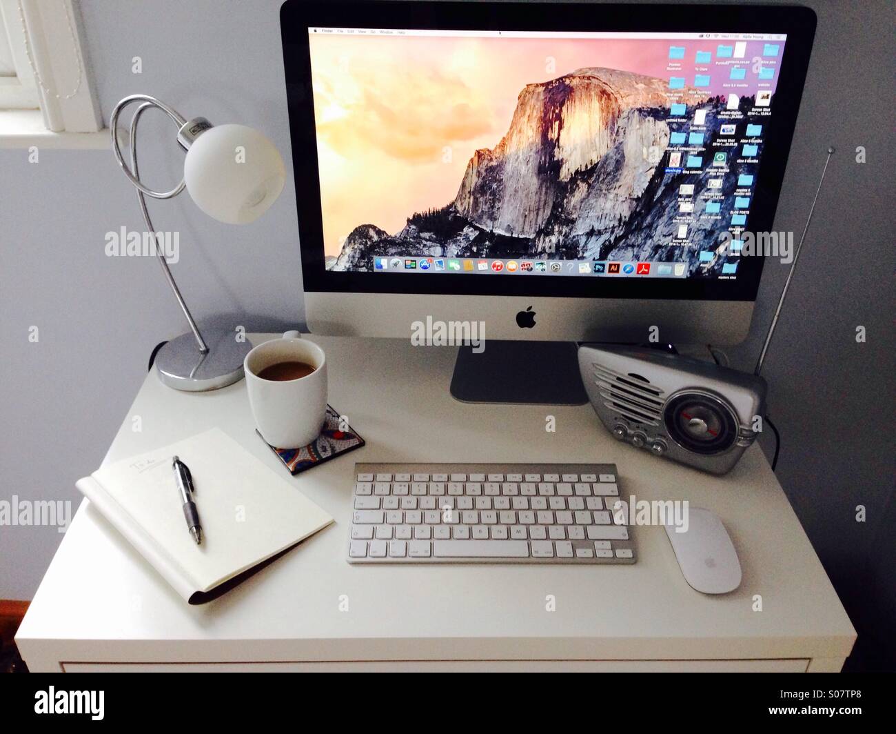 A home office with Mac desktop computer running the Yosemite operating system. Stock Photo