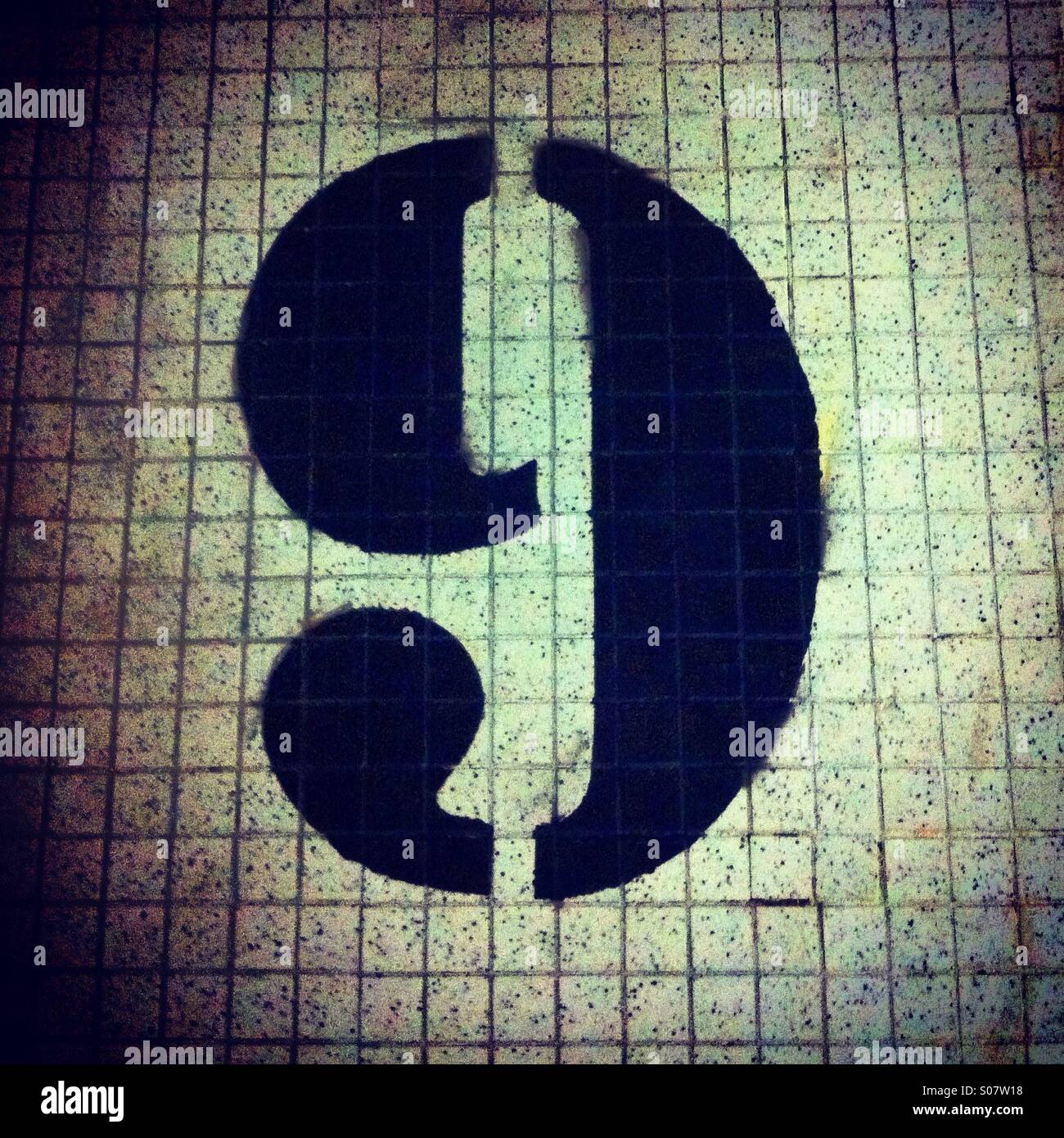 Number 9 stencil painted in black on a tile wall - Smartphone Captured Stock Image