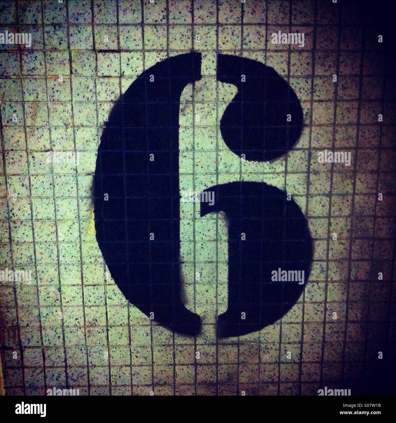 Number 6 stencil painted in black on a tile wall - Smartphone Captured Stock Image
