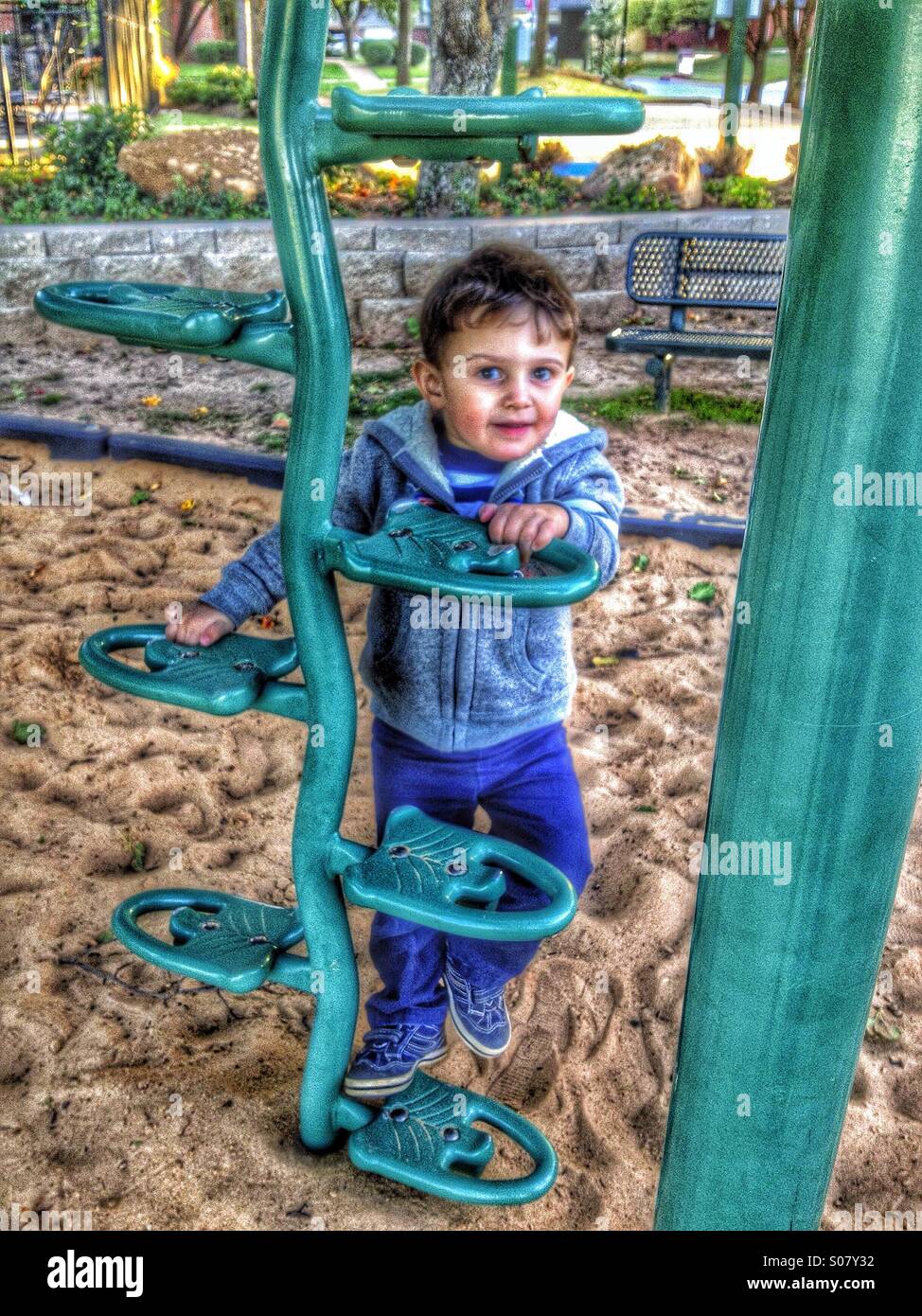 Cute smiling 3 year old boy climbing on playground gym. HDR Stock Photo Alamy