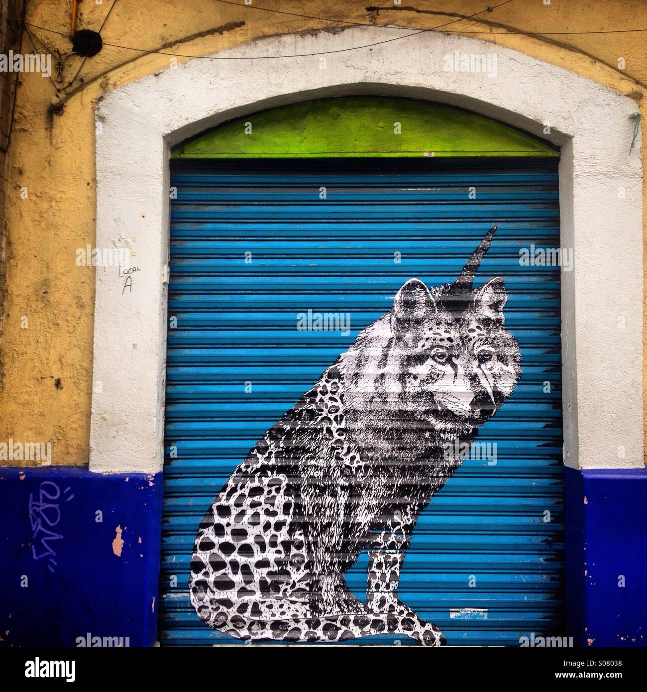 An image of a black&white unicorn-wolf-cheetah created by artist Diana Garcia, decorates a blue door in Colonia Roma, Mexico City, Mexico - Smartphone Captured Stock Image