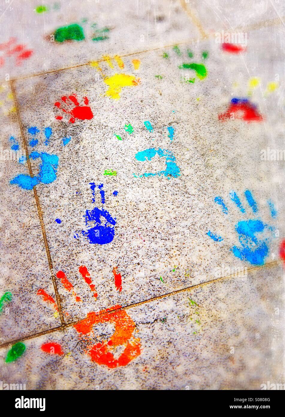 Children's hand prints in bright paint colours Stock Photo