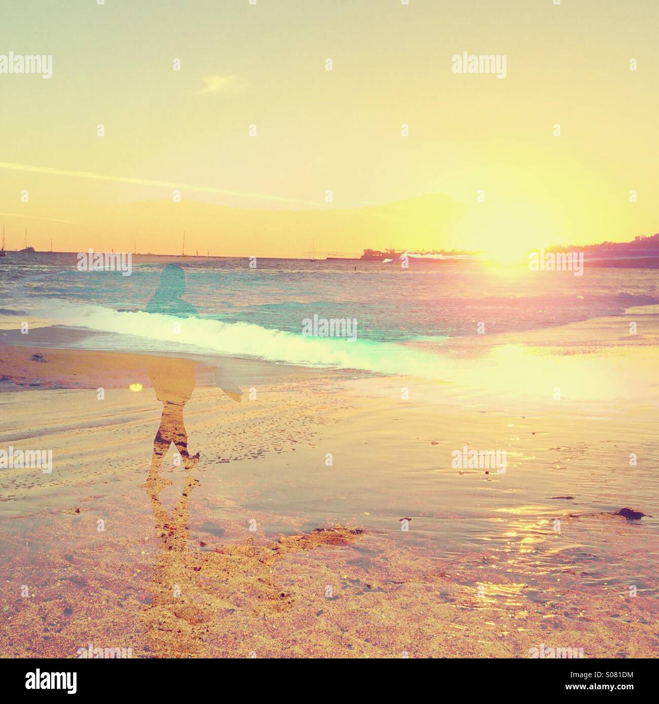 Double exposure of a female walking on the beach alone at sunset. - Smartphone Captured Stock Image