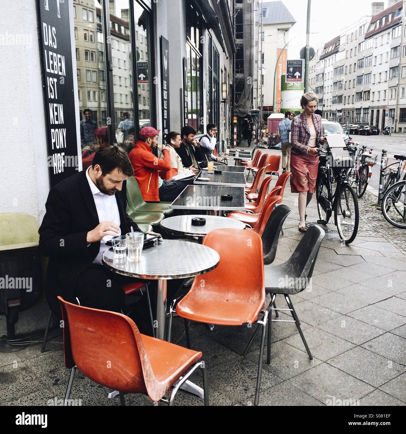People sitting at outdoor tables at St Oberholz cafe on corner of Torstrasse and Rosenthaler Strasse, Mitte, Berlin, Germany Stock Photo