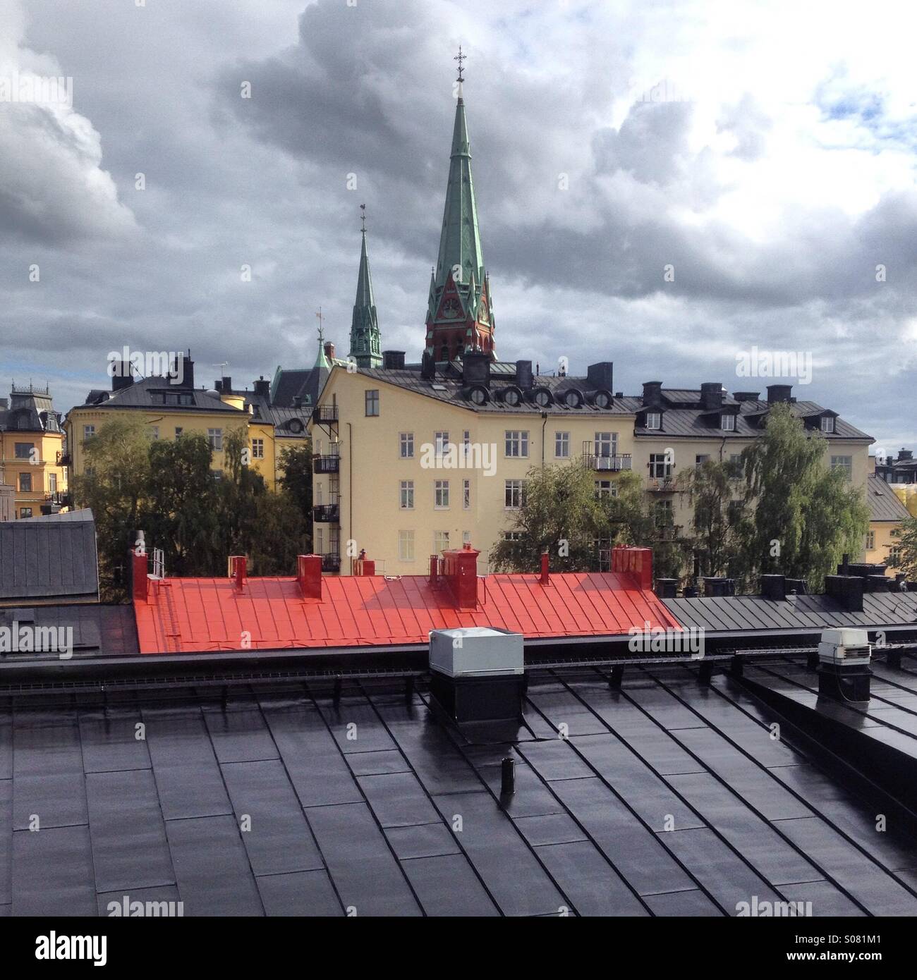 Sunshine after rain over traditional metal plate rooftops in the centre of Stockholm in Sweden - Smartphone Captured Stock Image