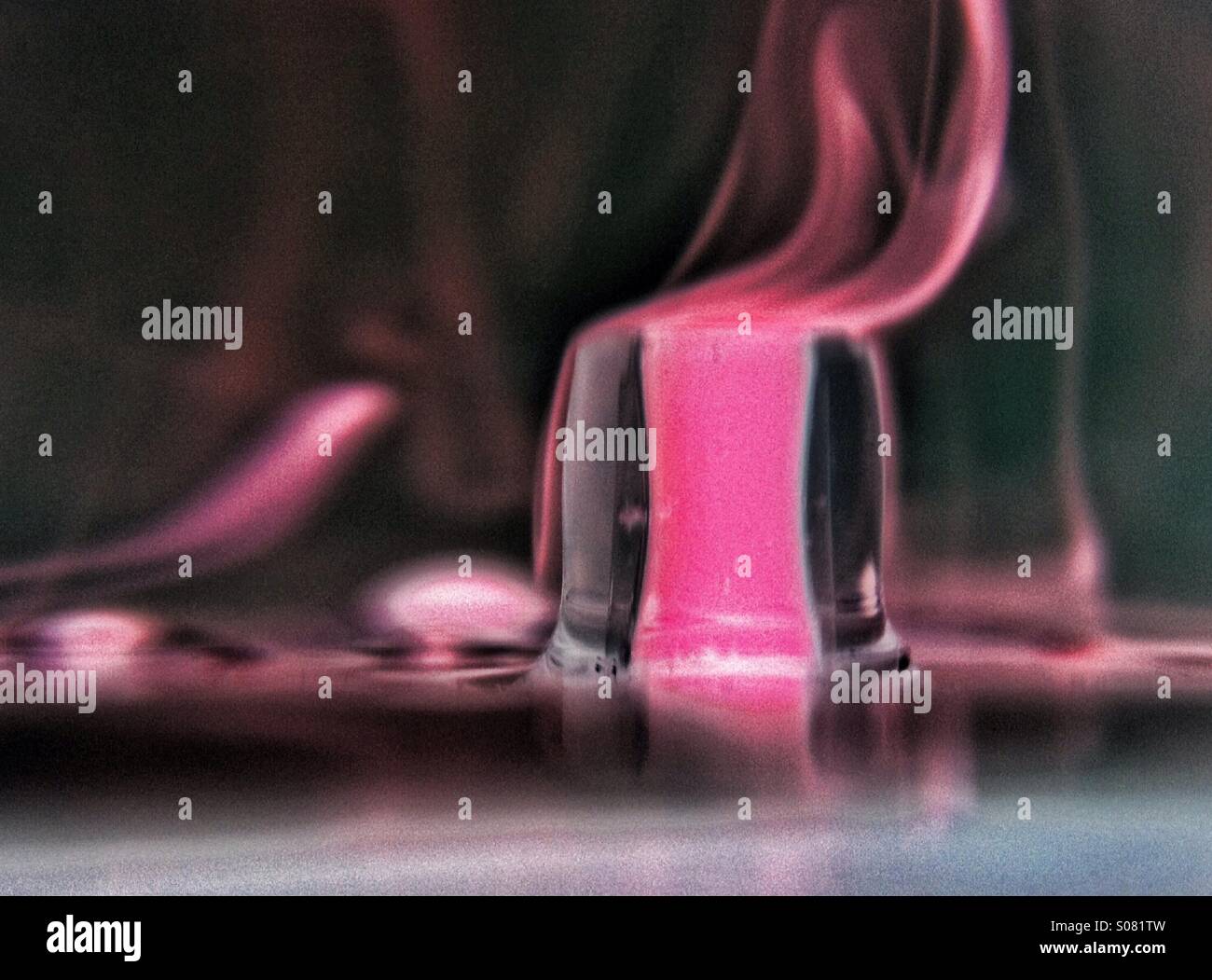 Colour inverted photo of dropper dropping coloured water into clear water - Smartphone Captured Stock Image