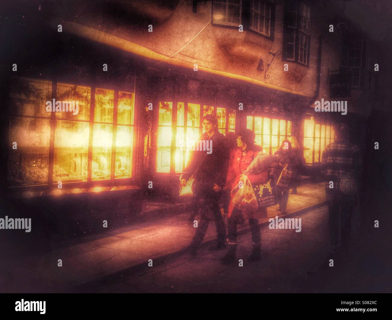 Shoppers walking along a shopping street at night York North Yorkshire England UK - Smartphone Captured Stock Image