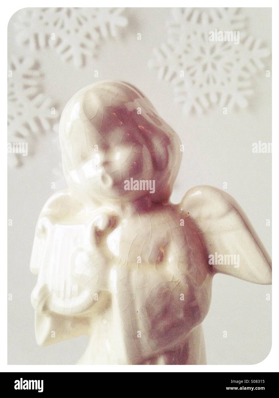 An angel Christmas figurine with a snowflake background. Stock Photo