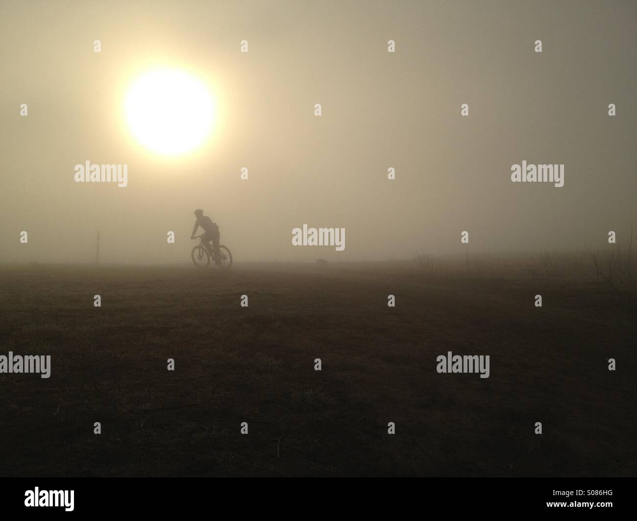 Mountain biker riding on a foggy morning at sunrise in Laguna beach California. Stock Photo