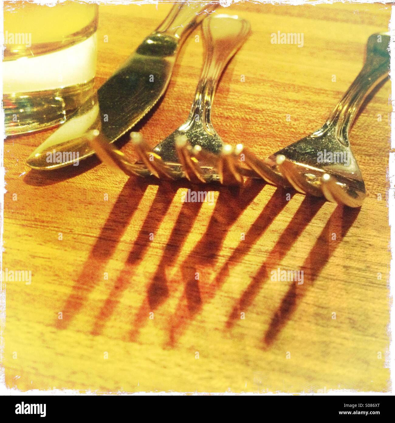 Forks, knife, water, glass, restaurant, table, wood, silverware, dinnerware, dining, out, shadows, cafe, utensils, closeup, textures - Smartphone Captured Stock Image