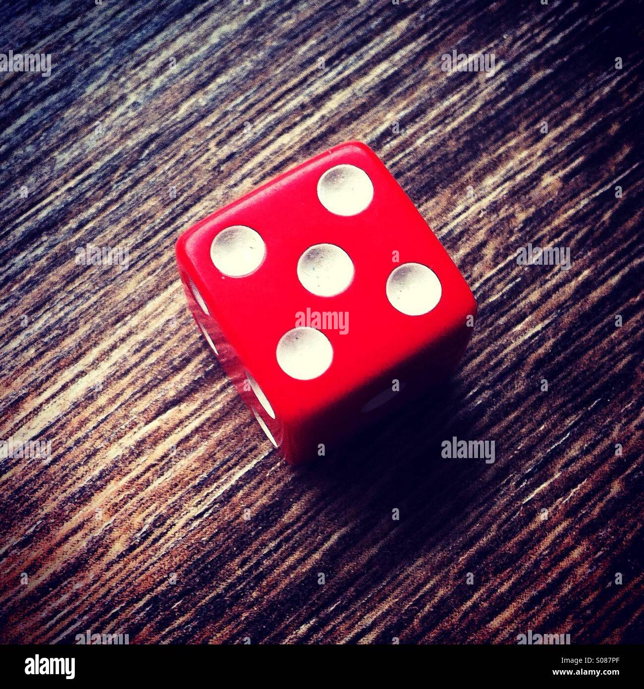 Red dice showing number 5 Stock Photo