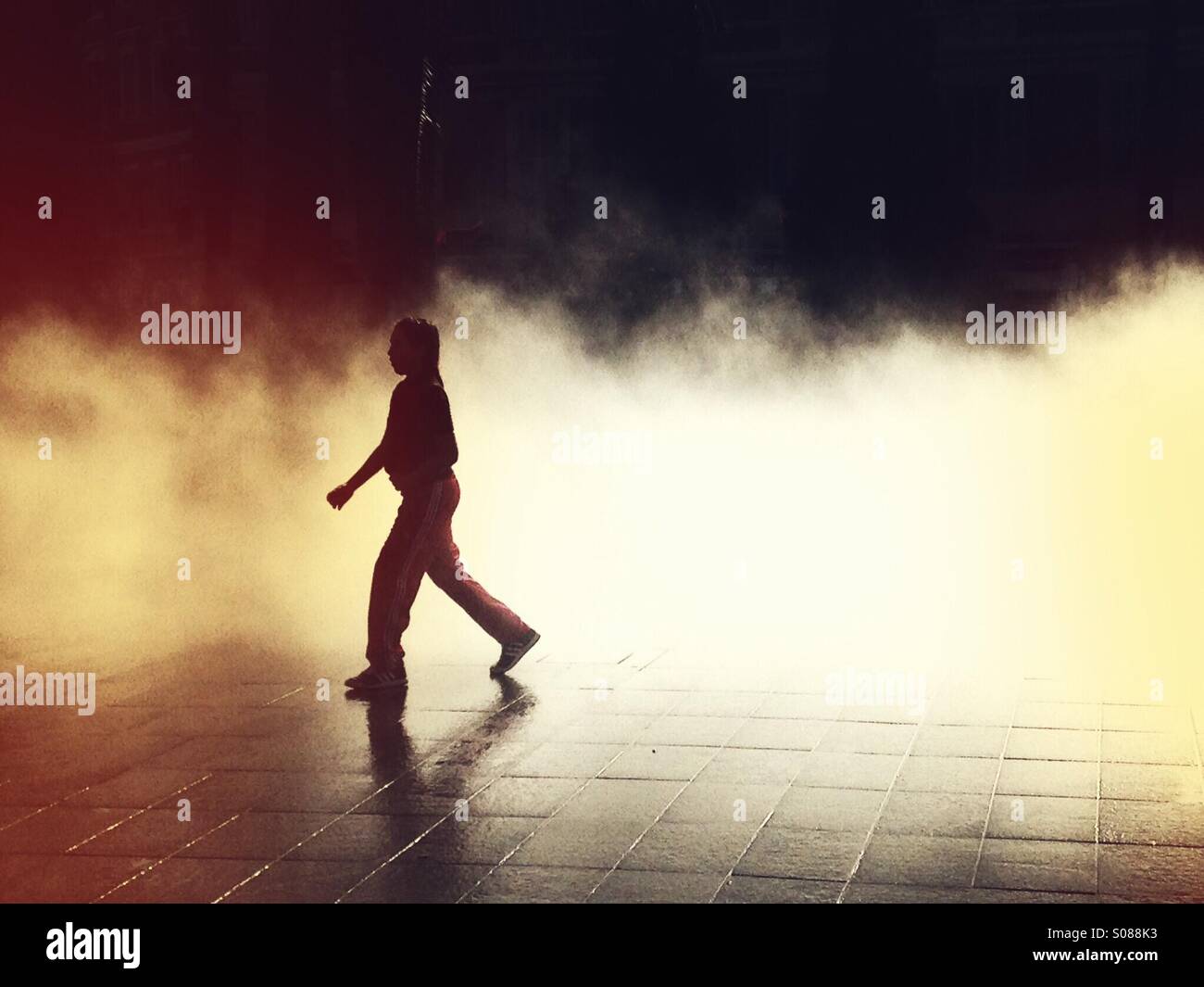 Woman  in shadows waking through a mist. - Smartphone Captured Stock Image