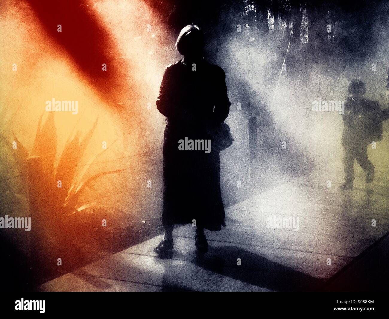 Woman in the mist with a boy following her. - Smartphone Captured Stock Image