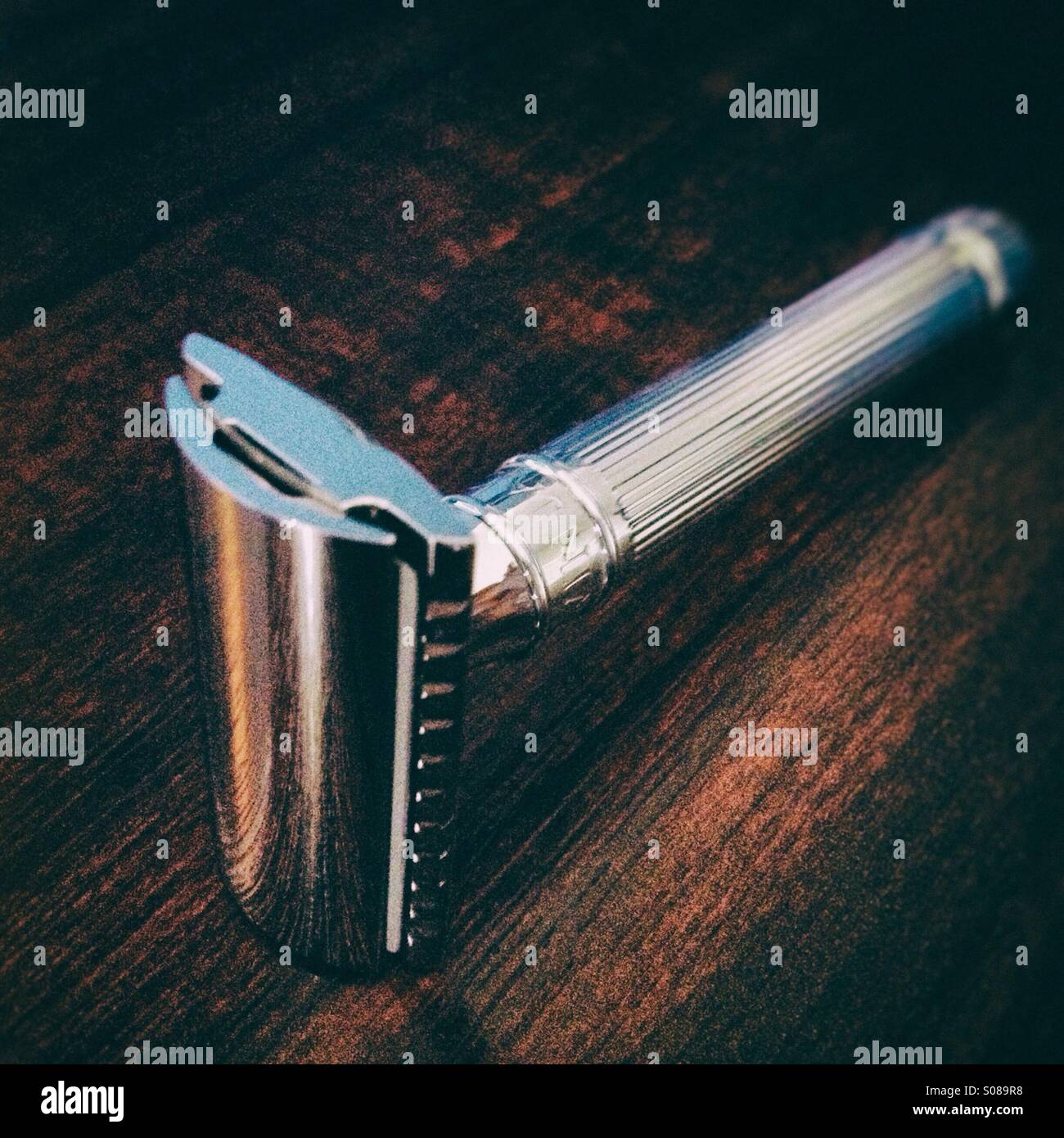 Double edge safety razor photographed on a wooden worktop Stock Photo