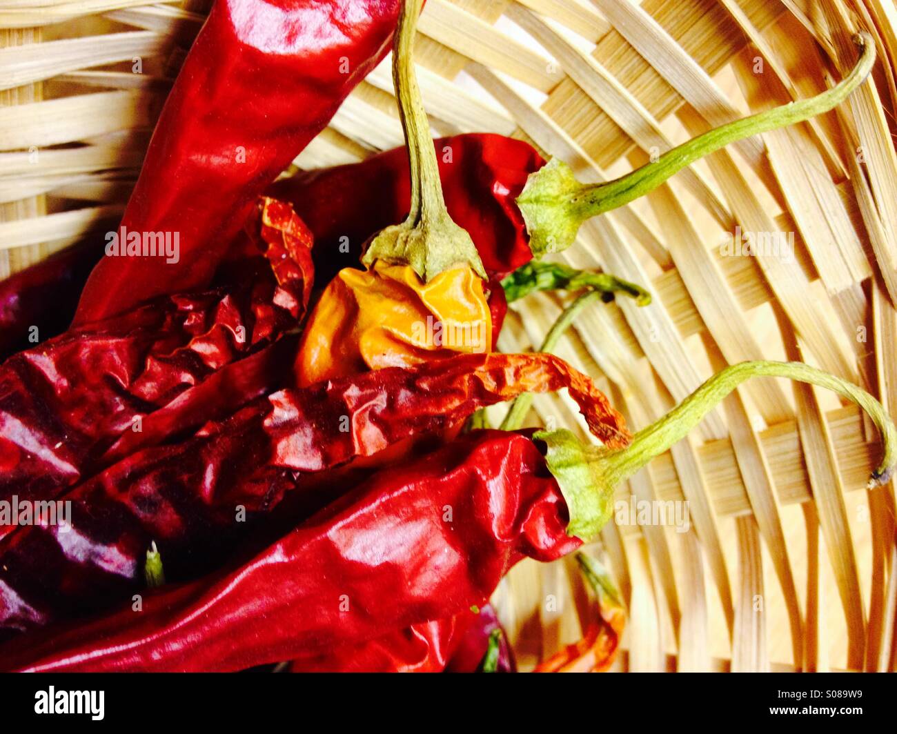 Dried red chilli peppers in a wicker basket - Smartphone Captured Stock Image