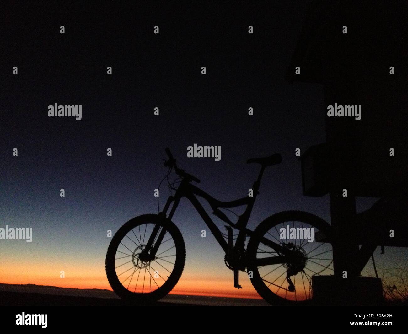 Mountain bike silhouette at sunset. Stock Photo