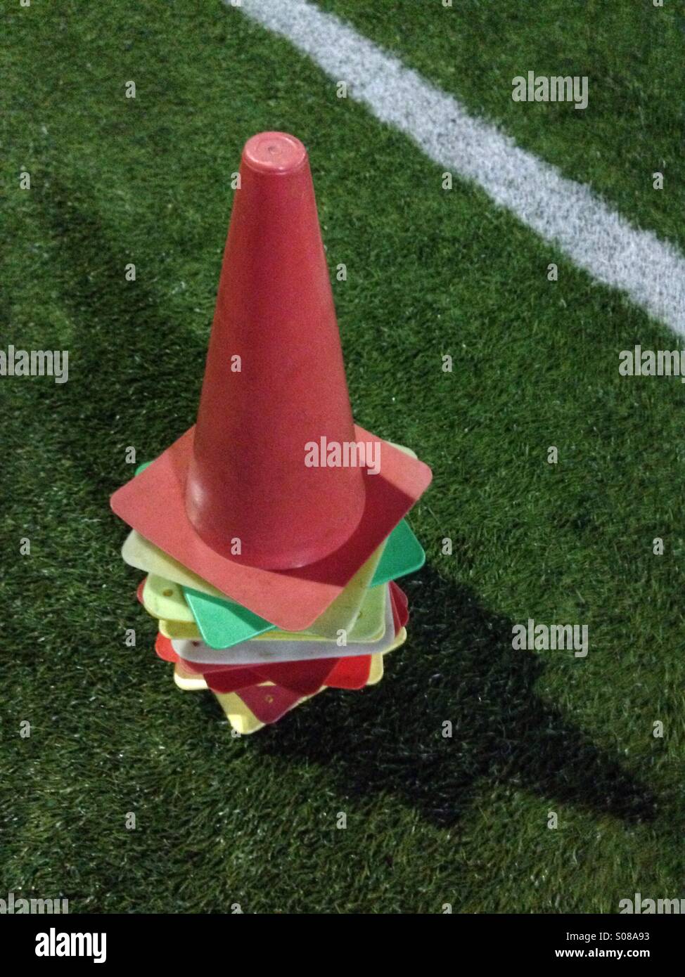 Pile of colorful training cones in green grass field - Smartphone Captured Stock Image
