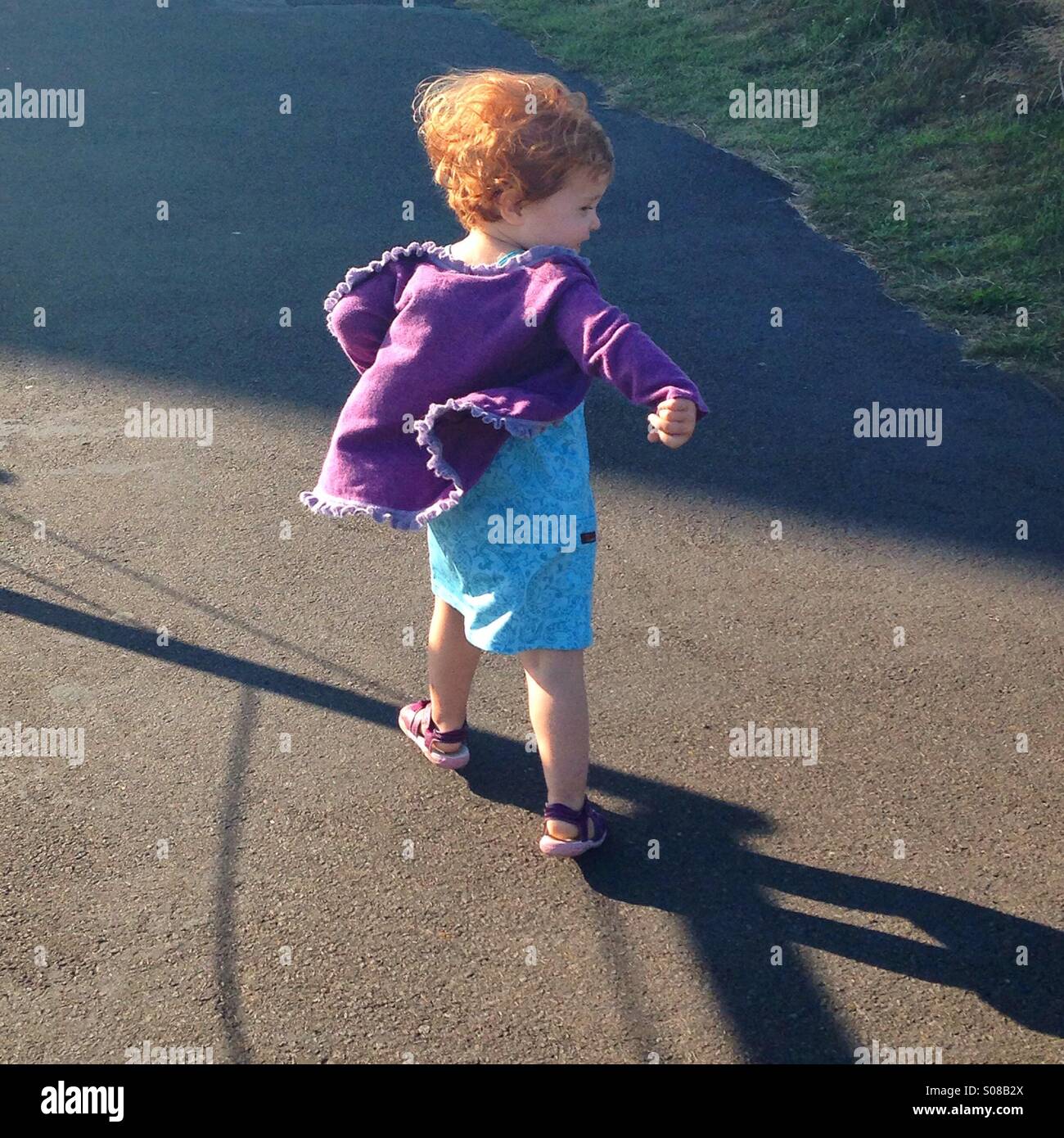 Red haired little girl skipping, Oregon coast Stock Photo