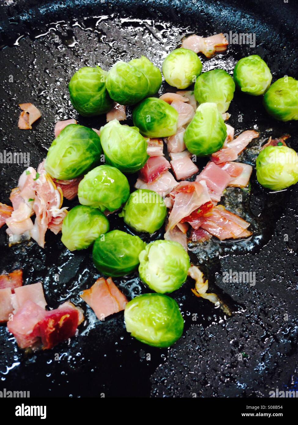 Brussels sprouts with bacon in pan Stock Photo