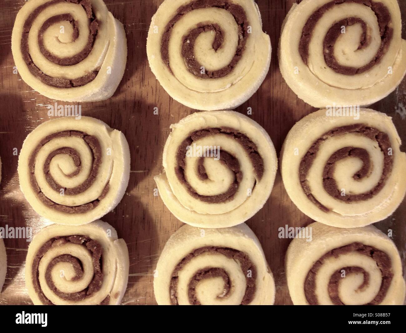 Raw cinnamon rolls in a pan for baking Stock Photo