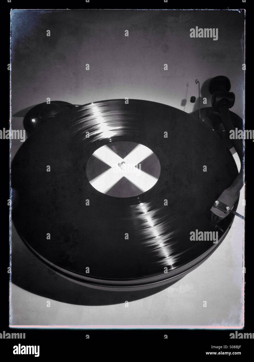 Black and white Polaroid style image of a Record turntable on a plain background - Smartphone Captured Stock Image