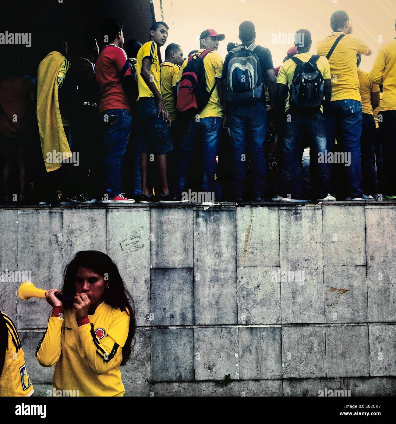 A Colombian girl plays a trumpet while watching the football match between Colombia and Uruguay at the FIFA World Cup 2014, in a park in Cali, Colombia, 28 June 2014. Stock Photo
