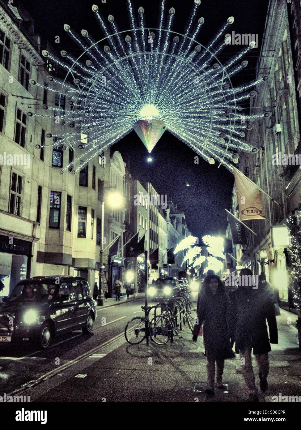 A couple stroll under Christmas lights in a festive London - Smartphone Captured Stock Image