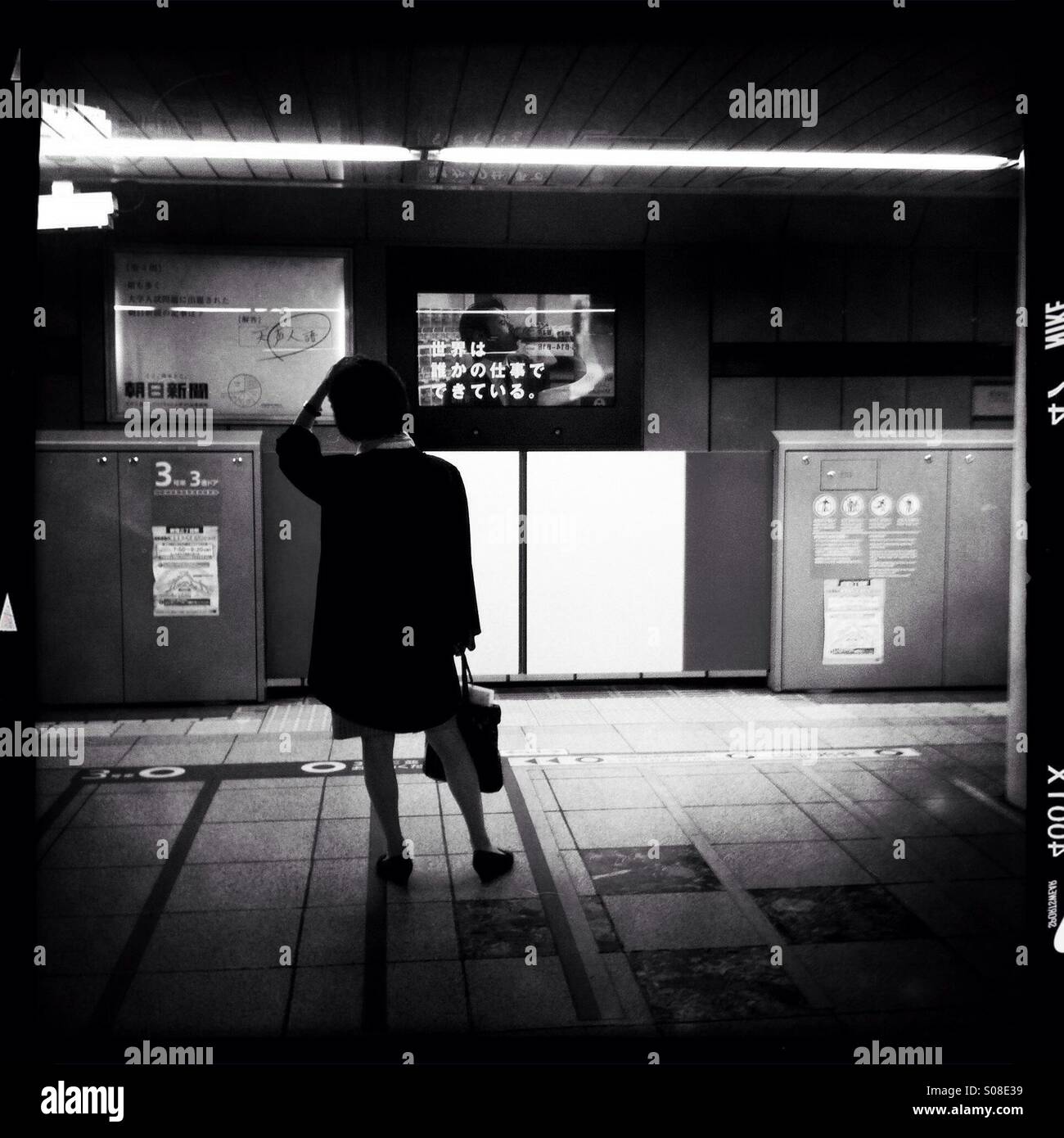 A woman waits for a train arrival at Tokyo metro in Tokyo, Japan. Stock Photo