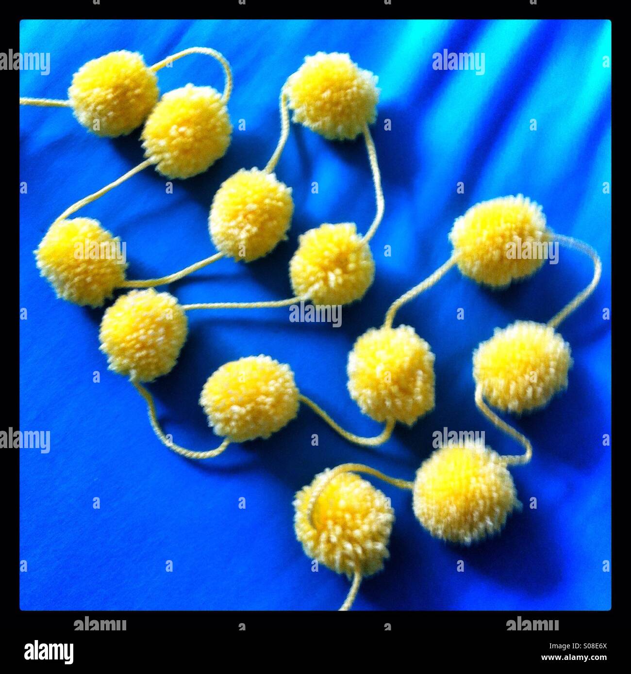 Yellow string or garland of pom-poms - Smartphone Captured Stock Image