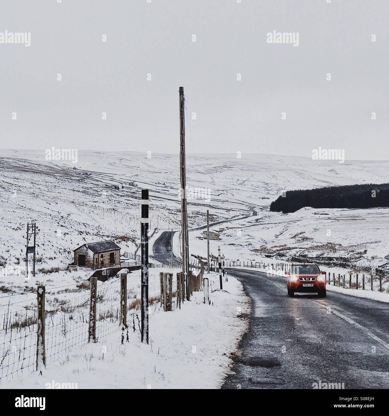 A Nissan keep travels up a snowy country road near Weardale, UK. - Smartphone Captured Stock Image