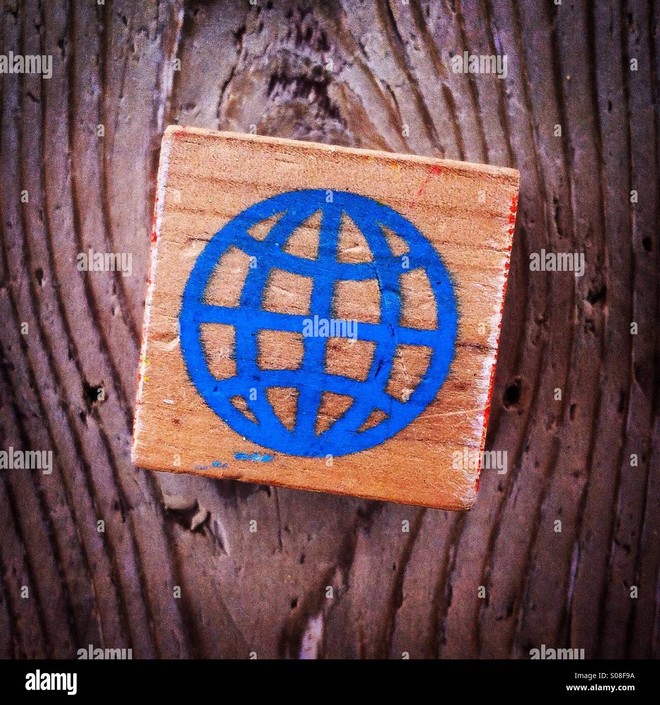 World symbol painted on a wood block - Smartphone Captured Stock Image