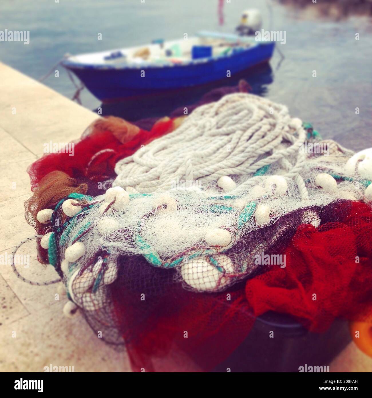 Fishing net with small boat in blurred background Stock Photo