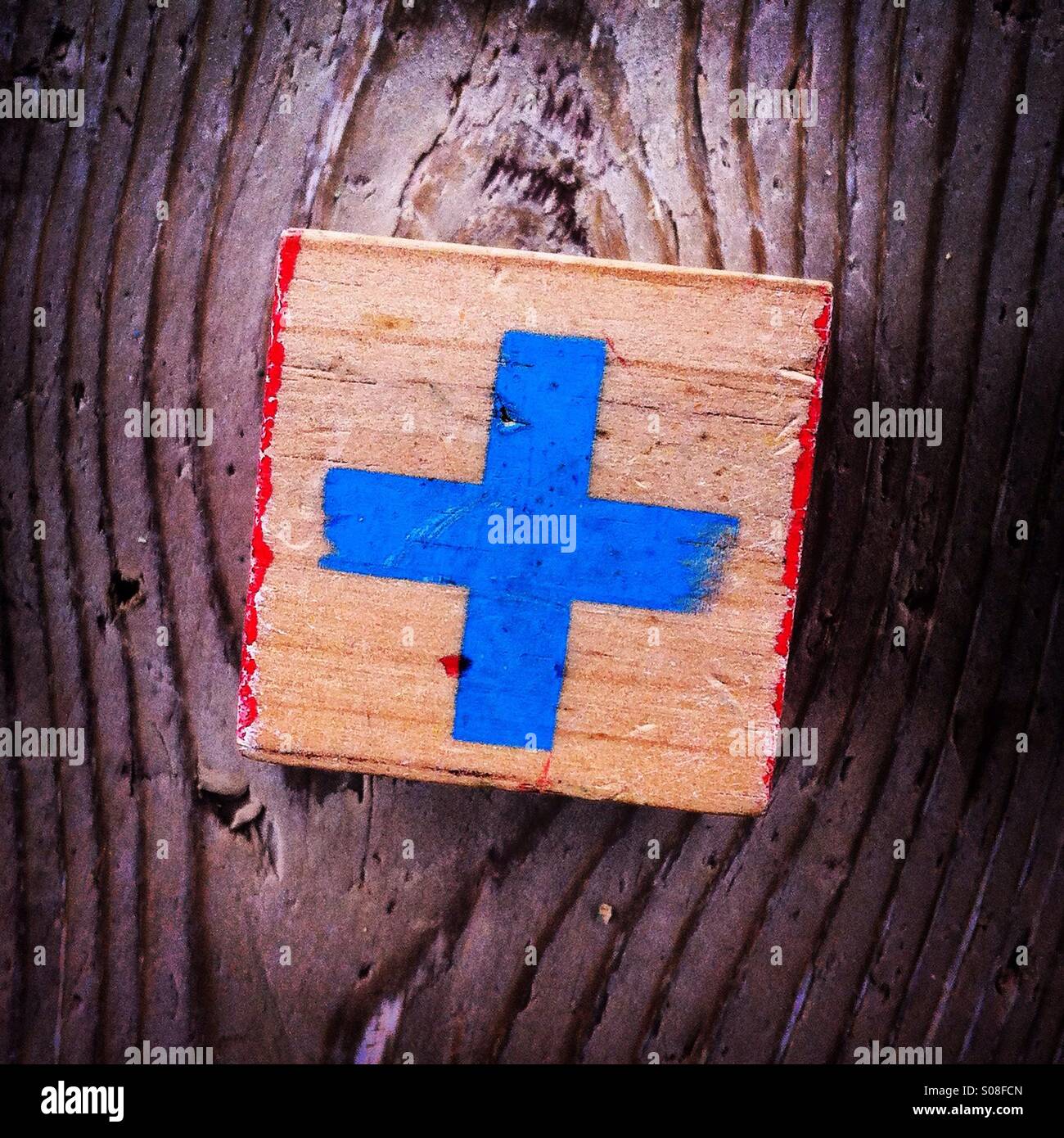 Cross in blue color on a wood block - Smartphone Captured Stock Image