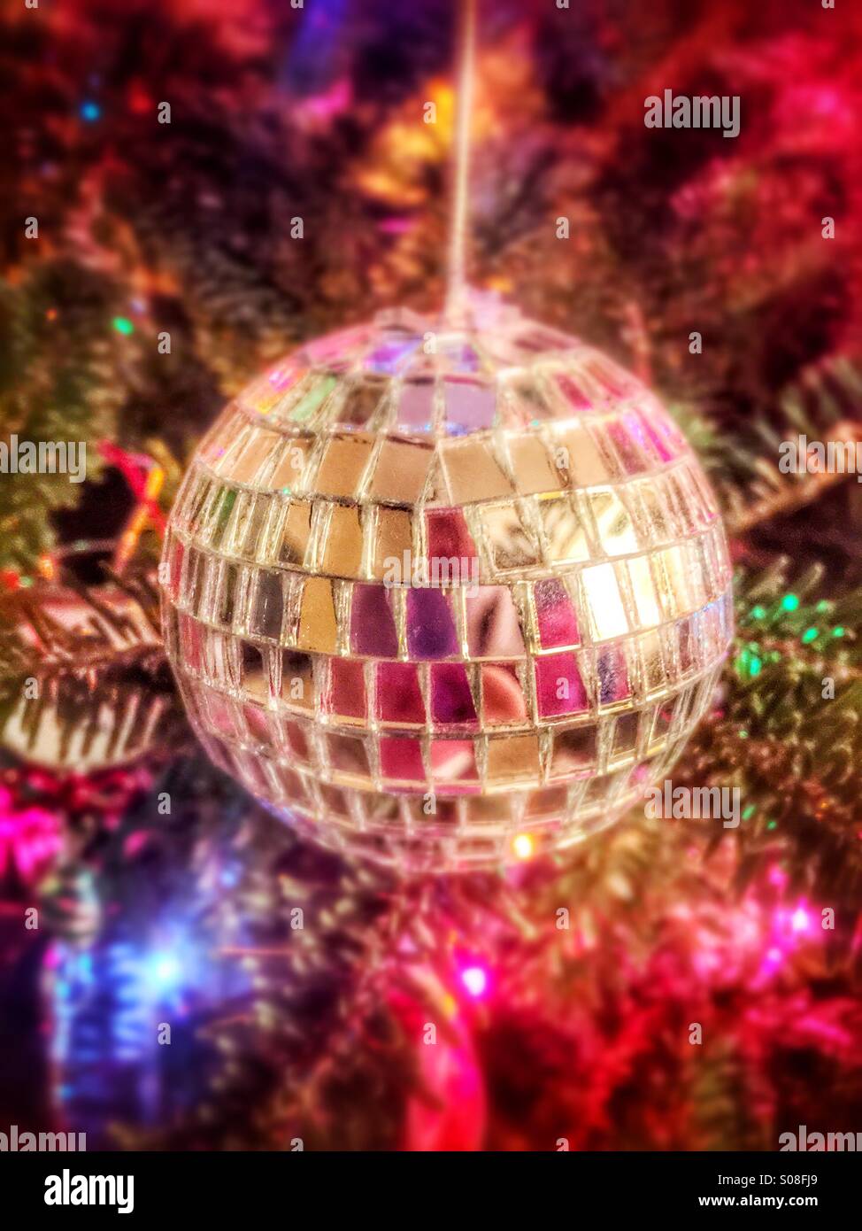 A mirror ball ornament hanging on a Christmas tree - Smartphone Captured Stock Image