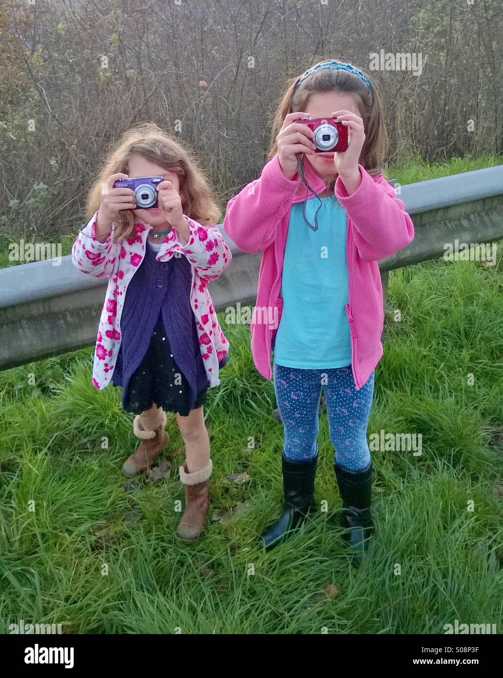 Two young children using digital cameras taking photos Stock Photo - Alamy