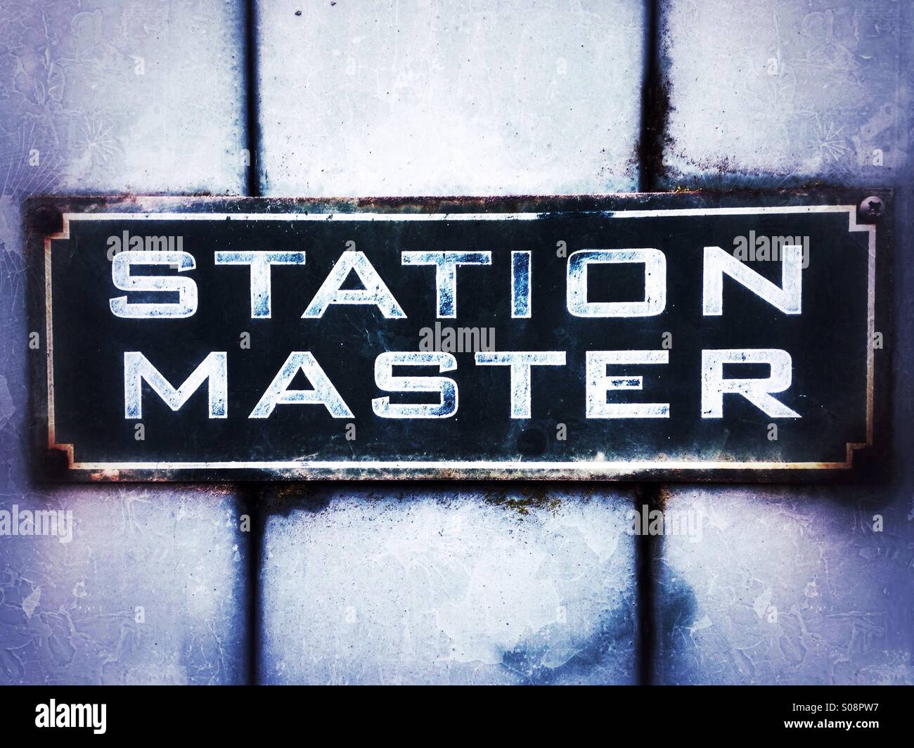 Old faded station master sign on a wooden door Stock Photo