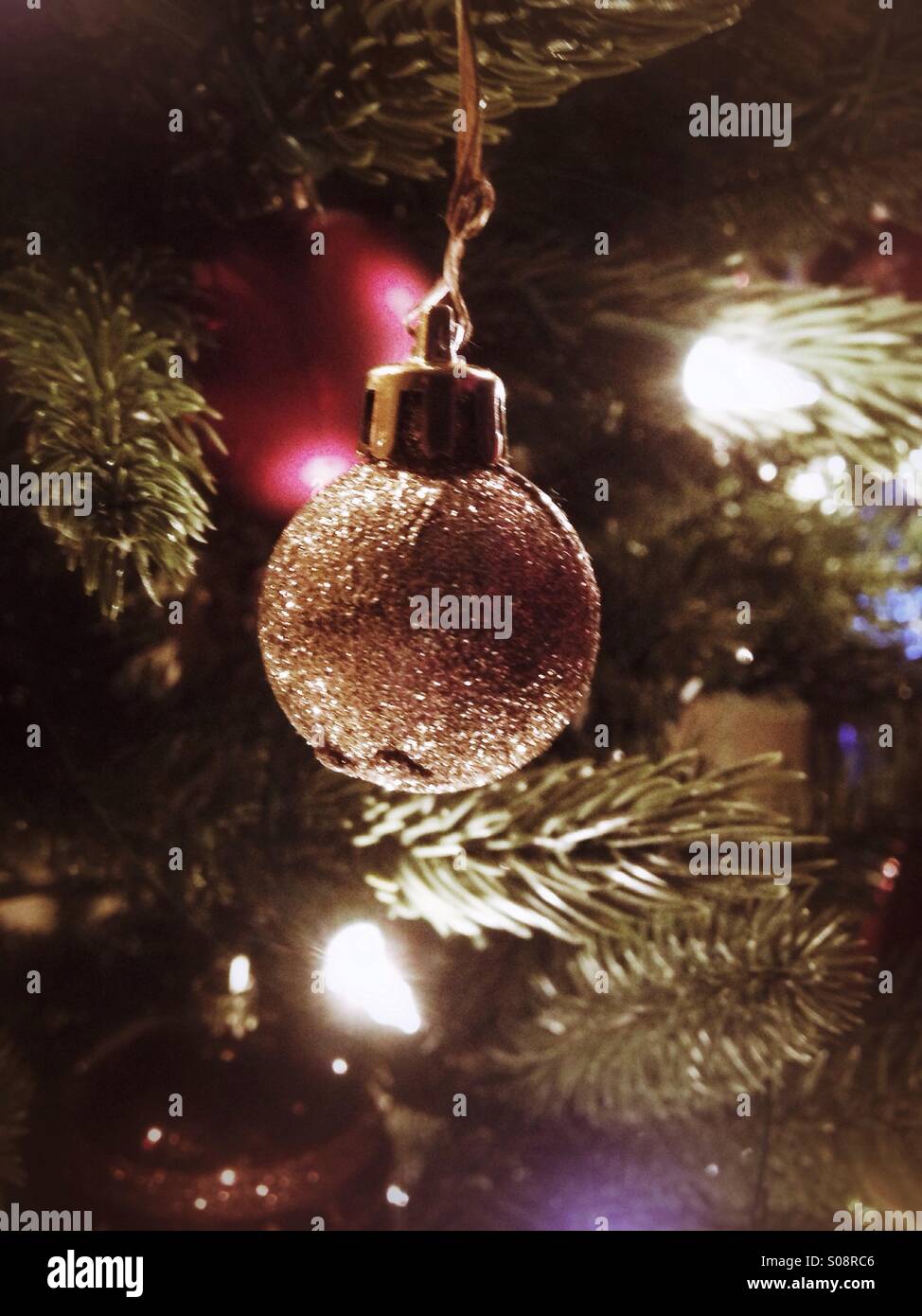 A small glittery ball on the Christmas tree. - Smartphone Captured Stock Image