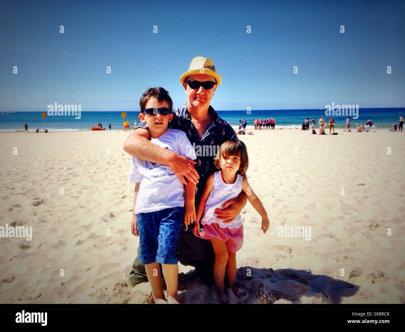 Dad and children on Bondi beach Stock Photo