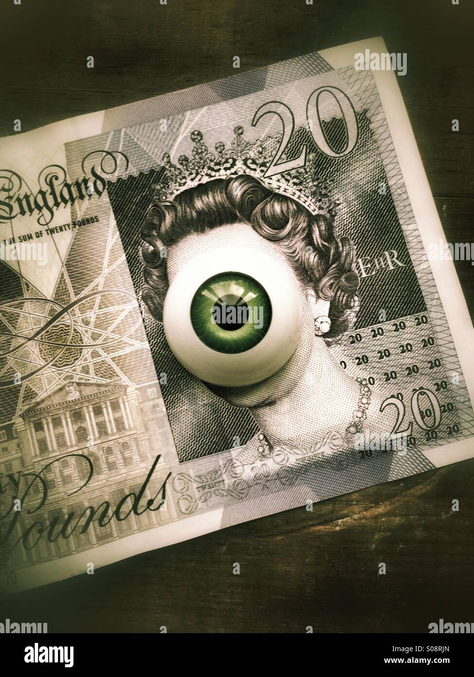 Your money is watching you , eyeball over a 20 pound note Stock Photo