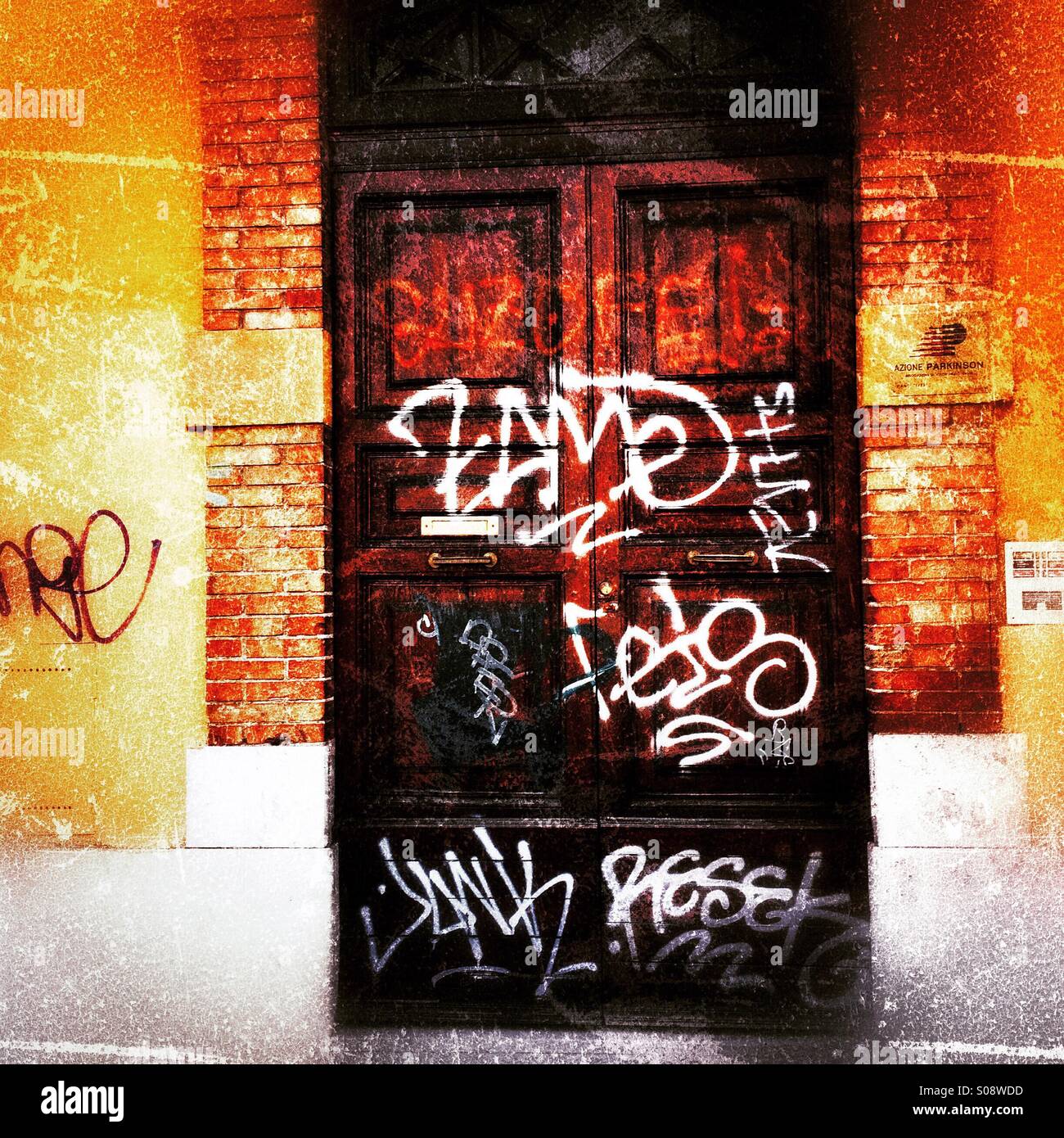 A strong wooden door in Rome covered in graffiti - Smartphone Captured Stock Image