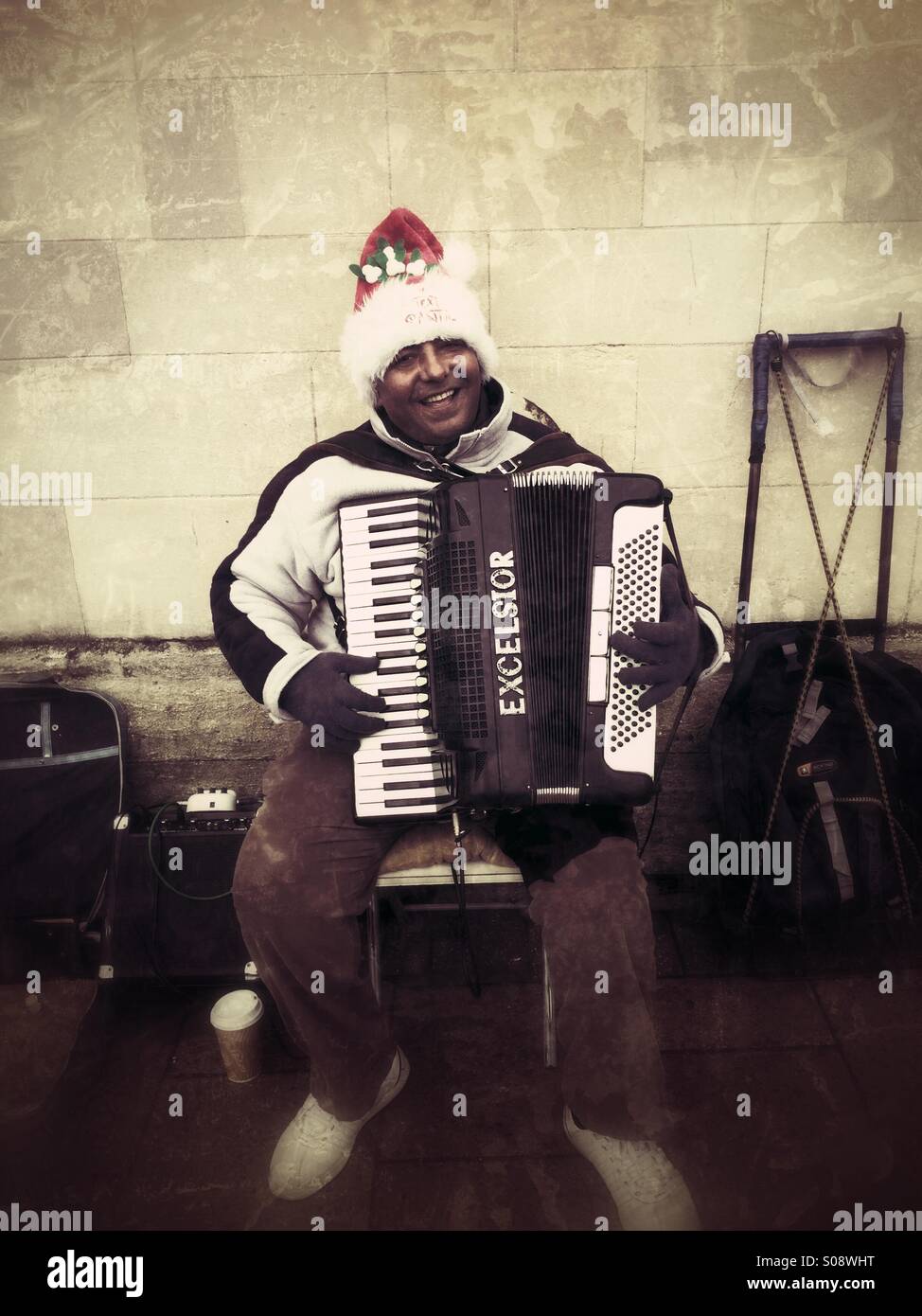 A happy accordionist in festive clothing entertains shoppers in Epping, Essex Stock Photo