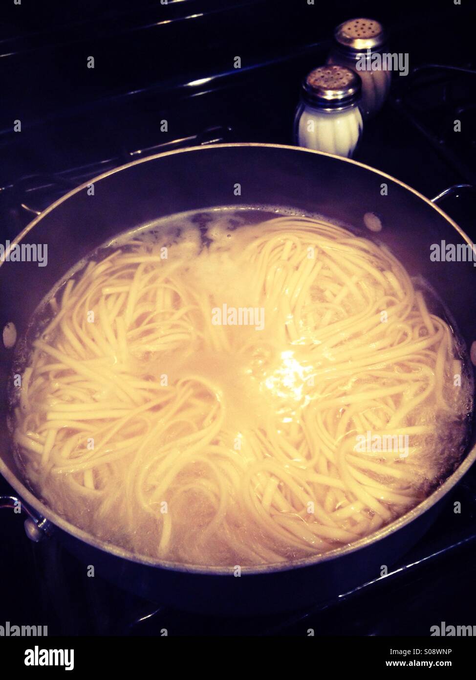 A pot of noodles cooking on a stove Stock Photo Alamy