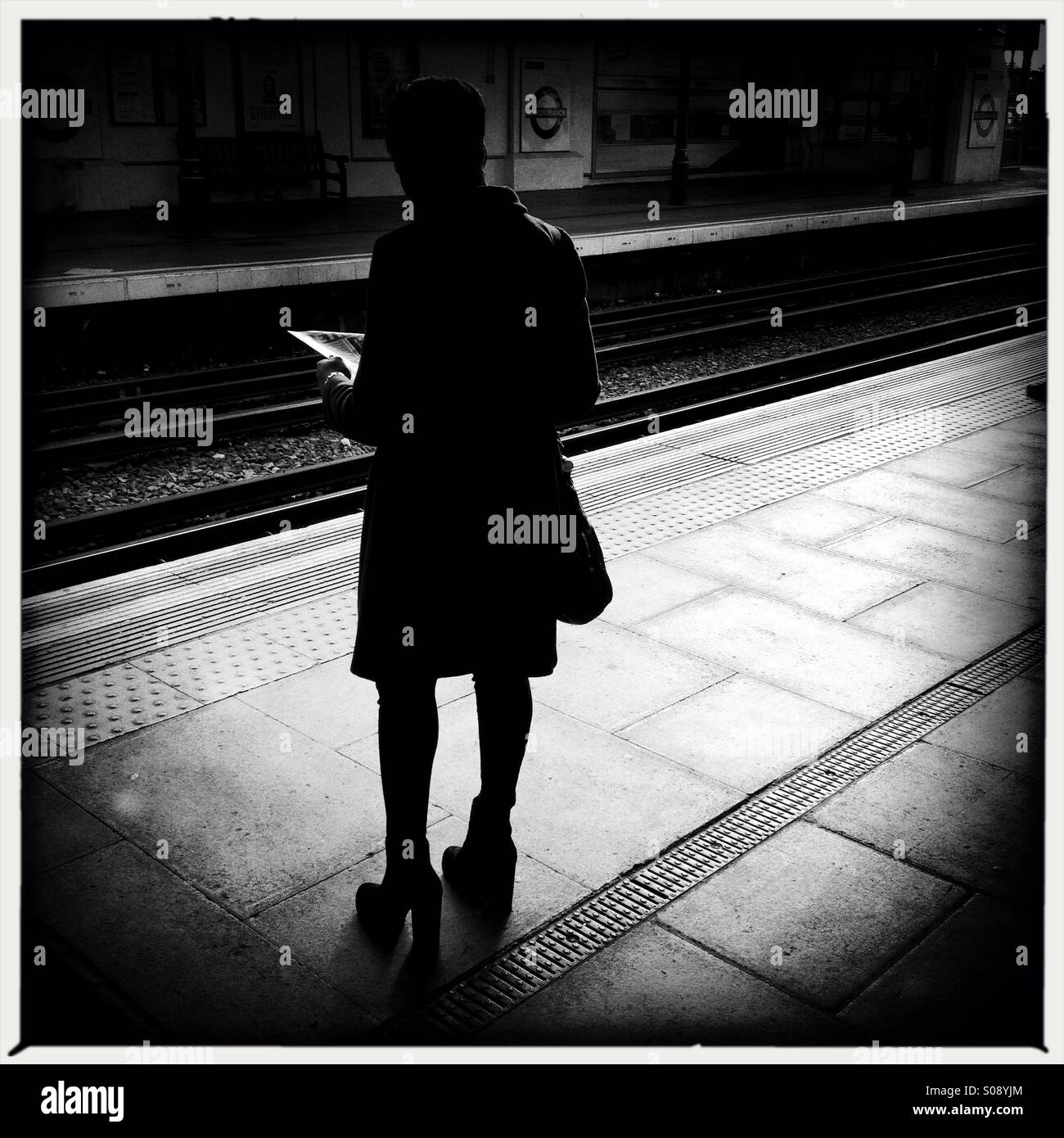 Silhouetted image if a commuter at London Underground station in London - Smartphone Captured Stock Image
