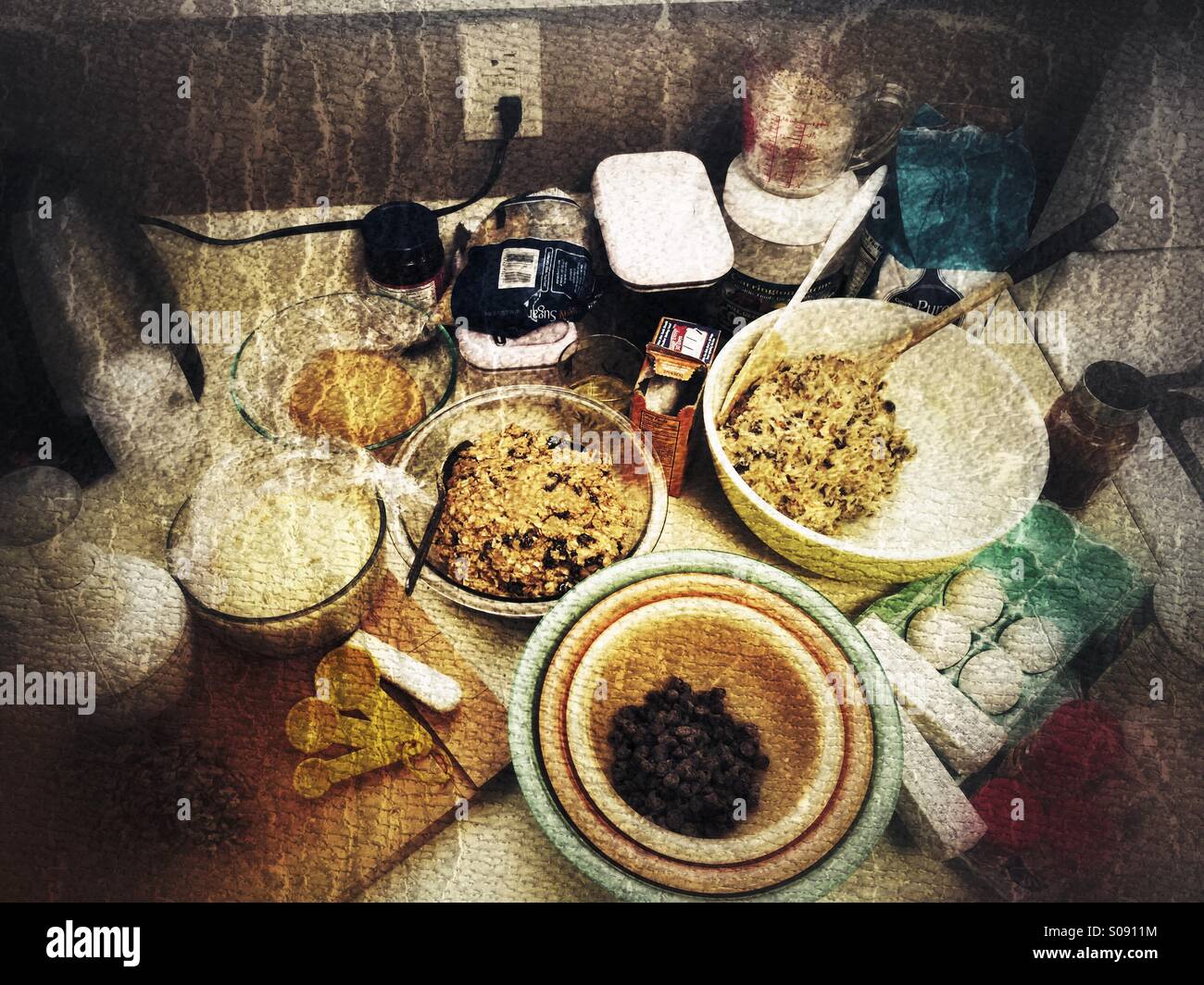 Darkened grungy textured photo of ingredients for homemade cookies on the kitchen counter Stock Photo