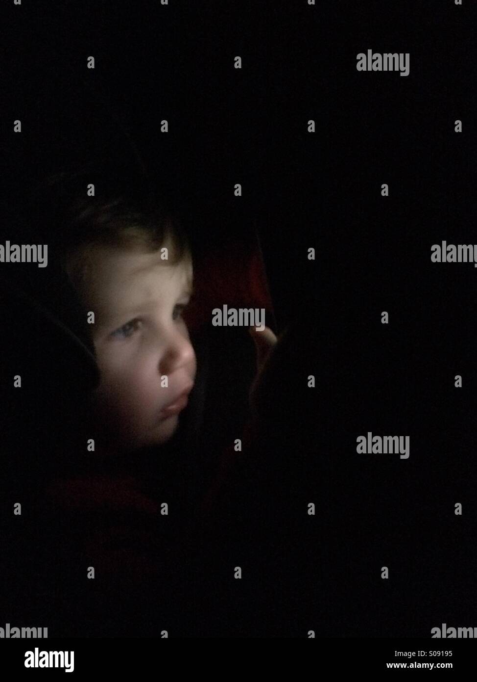 Child looking through the dark Stock Photo